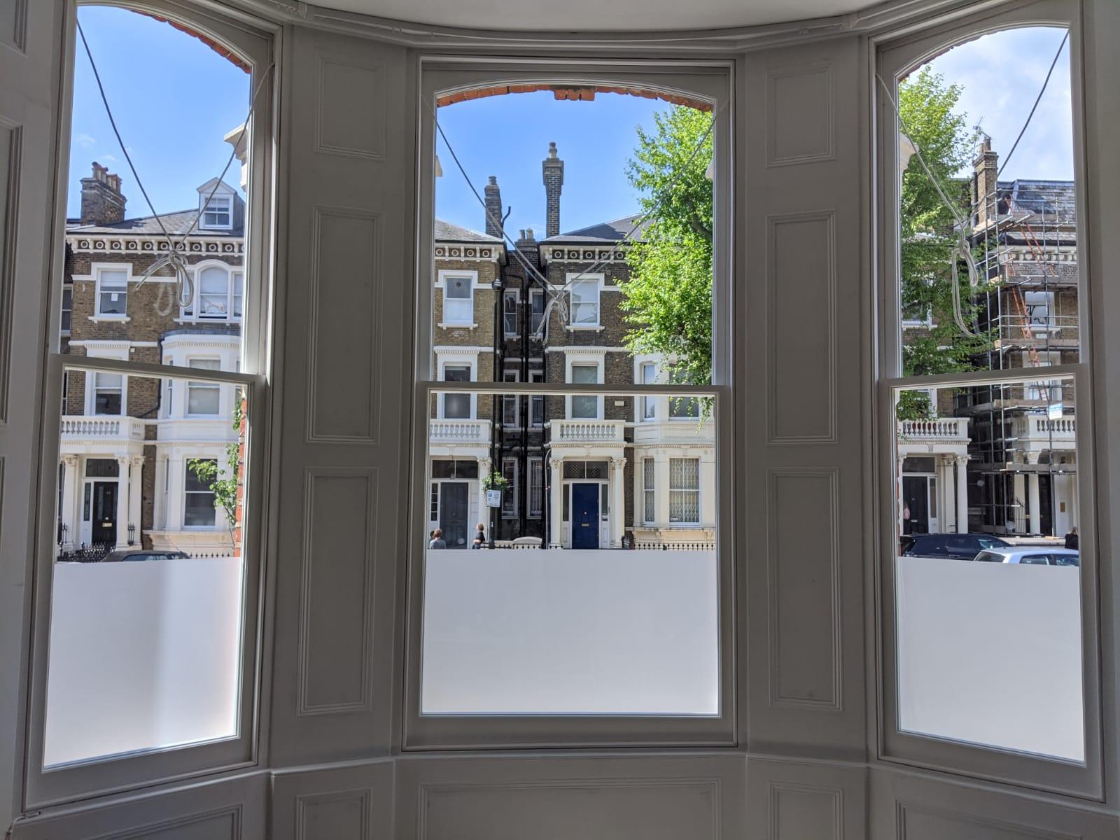 The image shows a bay window of restored and refurbished sash windows.